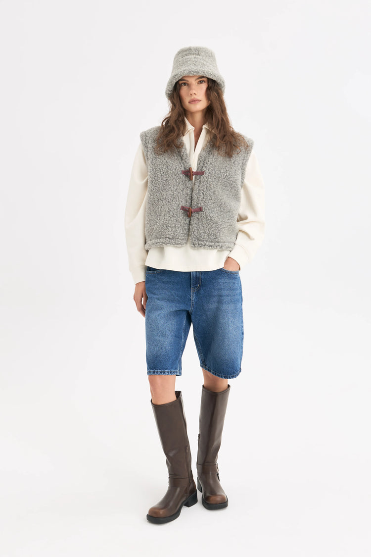 [pl][Modelka ma 179 cm wzrostu i nosi rozmiar S] [en][The model is 179 cm tall and wears size S] [de][Das Model ist 179 cm groß und trägt Größe S]  wełniana kamizelka merino szara z guzikiem merino wool vest stone grey