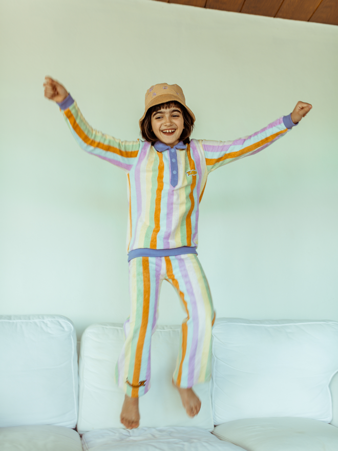 [pl][Modelka ma 134 cm i nosi rozmiar 7-8 lata] [en][The model is 134 cm and wears size 7-8 years] [de][Das Model ist 134 cm groß und trägt Größe 7-8 Jahre] bawełniane frotowe spodnie dziecięce w paski synset stripes bawełna organiczna outfit kapelusz bluza zestaw