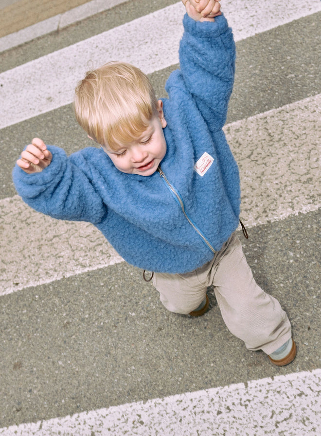 [pl][Model ma 2,5 roku i nosi rozmiar 3-4 lata] [en][The model is 2,5 years old and wears a size 3–4 years] [de][Das Model ist 2,5 Jahre alt und trägt die Größe 3–4 Jahre] wełniana kurtka bomberka merino dziecięca niebieska ice blue merino wool bomber jacket jacke