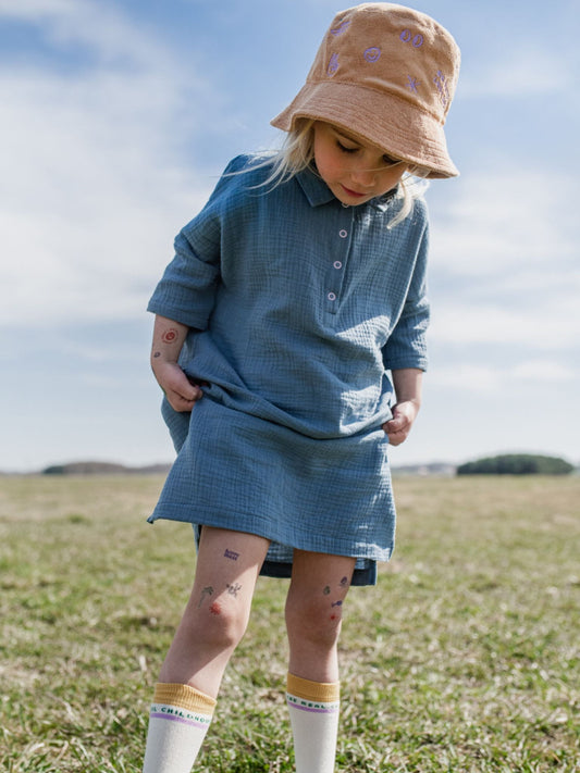 [Marcelinka ma 122 cm wzrostu i nosi sukienkę w rozmiarze 5-6 lat] dziecięca sukienka muślinowa niebieska bawełna organiczna storm blue muslin dress organic cotton dziecko dziewczynka kapelusz frotowy stylizacja 