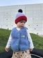 [pl][Model ma 90 cm wzrostu i nosi rozmiar 1-2 lata] [en][The model is 90 cm tall and wears size 1-2 years] [de][Das Model ist 90 cm groß und trägt Größe 1-2 Jahre] kamizelka wełniana merino dziecięca ice blue outfit stylizacja czapka 
