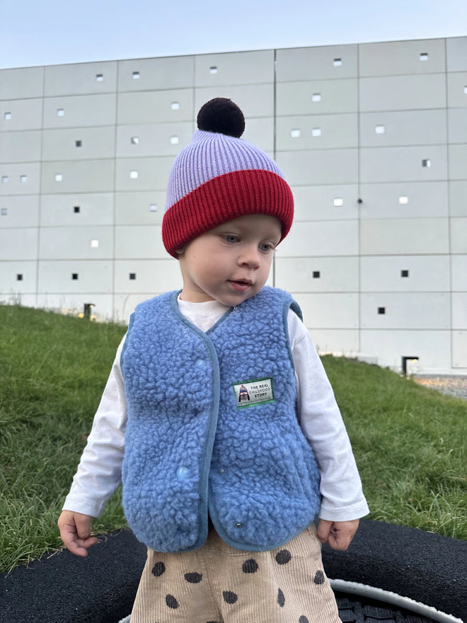 [pl][Model ma 90 cm i nosi rozmiar 1-2 lata] [en][The model is 90 cm and wears size 1-2 years] [de][Das Model ist 90 cm groß und trägt Größe 1-2 Jahre] kamizelka wełniana merino dziecięca ice blue outfit stylizacja czapka 