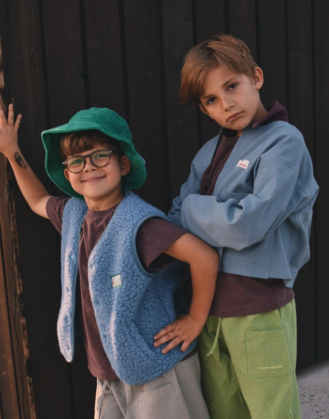 [pl][Model ma 118 cm i nosi rozmiar 7-8 lat] [en][The model is 118 cm and wears size 7-8 years] [de][Das Model ist 118 cm groß und trägt Größe 7-8 Jahre] kamizelka wełniana merino dziecięca ice blue outfit stylizacja kapelusz dzieci kurtka jeansowa spodnie 